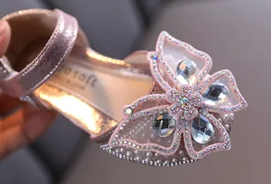 Gros plan détaillé du cristal papillon scintillant et des perles sur chaussures de princesse roses