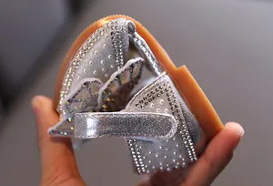 Close-up van de flexibiliteit van zilveren prinsessenschoenen voor meisjes met parels