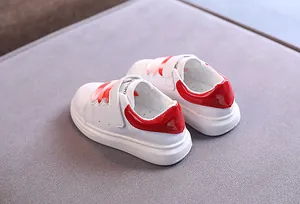 Dettaglio ravvicinato di sneaker bianche per bambini con tallone rosso e suola spessa