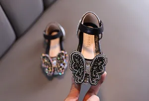 Detailansicht funkelnder schwarzer Mädchen-Prinzessin-Schuhe mit großem Strass-Schmetterling