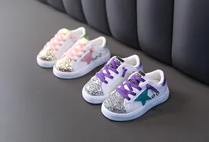 Stylish girl's white sneakers featuring glitter toes and stars with comfortable soft soles