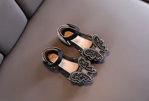 Detailansicht der schwarzen Mädchen-Prinzessinenschuhe mit Strass-Schmetterling