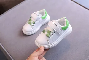 Vista dettagliata delle sneakers in pelle per bambini bianche con accenti verdi