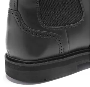 Dettaglio ravvicinato di stivale Chelsea in pelle nera con cuciture brogue ed elastico