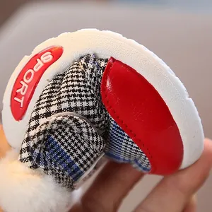 Flexible soft-sole baby walking shoes with checkered pattern and fur ball detail