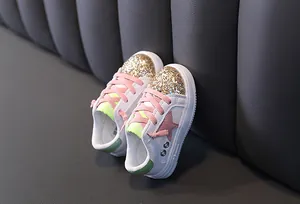 Close-up of girls' glitter sneakers with pink star design and breathable mesh