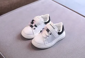 Dettaglio ravvicinato di sneakers in pelle bianca per bambini con lacci sfumati