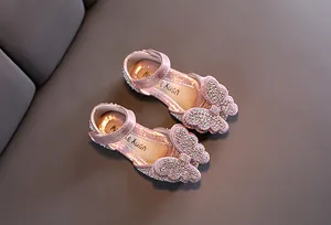Detailaufnahme von rosa Glitzer-Mädchenschuhen mit großer Schleife aus funkelnden Strasssteinen