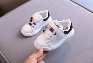 Dettaglio scarpe da ginnastica in pelle bianca per bambini con lacci sfumati