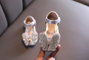 Nahaufnahme funkelnder silberner Prinzessinnenschuhe für Mädchen mit Strass-Schmetterling