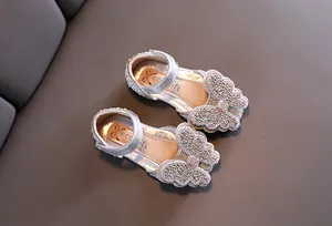 Detailansicht von funkelnden silbernen Prinzessinnenschuhen mit glitzernden Strass-Schmetterlingen