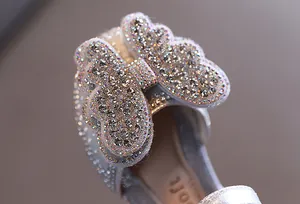 Makrodetail eines silbernen Prinzessinnenschuhs für Mädchen mit glitzerndem Strass-Schmetterling