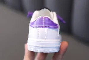 Close-up view showing the heel of stylish white girls' sneakers with purple metallic accents