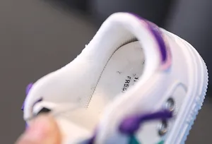 Close-up view of the breathable mesh lining and soft insole of the kids' white sneakers.