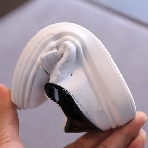 Sneakers bianche flessibili per bambini in morbida pelle con dettaglio nero al tallone