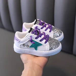 Stylish girls' white sneakers with silver glitter and purple laces, breathable mesh design.