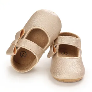 Close-up of metallic champagne baby Mary Jane shoes with soft sole and bow detail