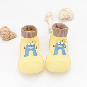 Close-up view of yellow breathable baby sock shoes with a blue cartoon character