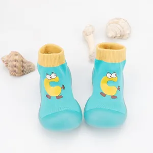 Detail of breathable baby sock shoes with cute cartoon 'C' and soft anti-slip rubber soles.
