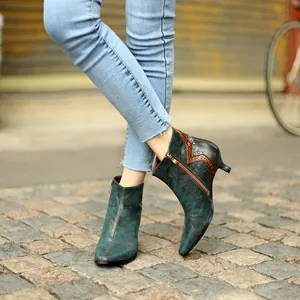 Détail de bottines vintage bleu-vert métallisé avec étoile léopard et petits talons.