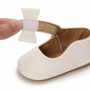 Detailed view of white baby princess shoe showing adjustable velcro strap and bow
