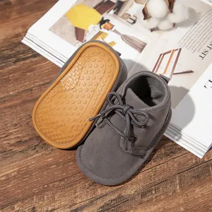 Close-up of grey baby boots with non-slip rubber star-patterned sole and lace-up design.