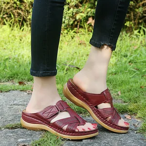 Close-up detail of burgundy platform wedge sandals featuring laser-cut criss-cross straps
