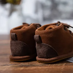 Detail of brown suede baby boots showing the reinforced heel and non-slip rubber sole.
