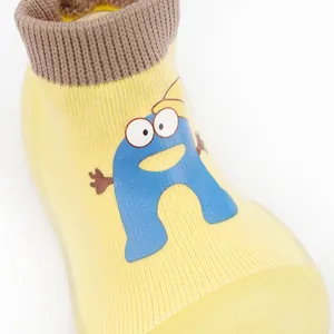 Detailed view of breathable yellow knit baby walking shoe with cute blue cartoon character