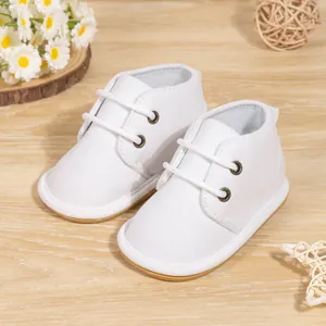 Detailed view of white baby walking shoes with laces and anti-slip rubber soles