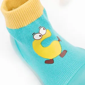 Close-up of breathable knit baby sock shoes with a cute yellow cartoon C character.