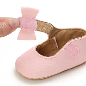 Close-up detail of soft pink baby princess walking shoe showing adjustable bow strap closure