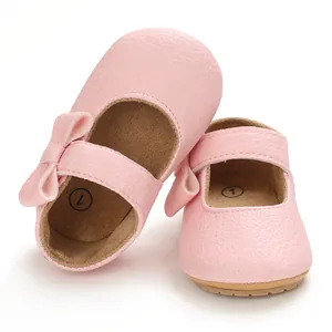 Close-up detail of cute pink baby princess shoes with bow and soft rubber sole for toddlers