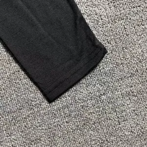 Detalle de primer plano del puño con doble costura de una camiseta negra de manga larga