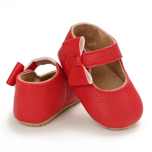 Close-up of red baby princess walking shoes with bow decoration and soft rubber sole