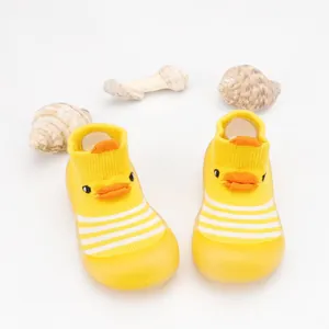 Detail view of yellow baby floor sock shoes with cartoon duck face and striped pattern