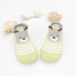 Close-up of baby floor sock-shoes with cute cartoon bear design and soft sole