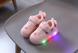 Close-up of pink toddler LED light-up sneakers with cute bear patterns and glowing sole