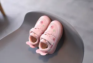 Detailed view of pink toddler shoes featuring cute bear patterns and velcro straps.