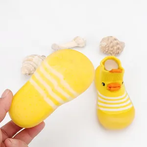 Detail of yellow cartoon duck baby walker shoes with soft rubber sole and knit upper