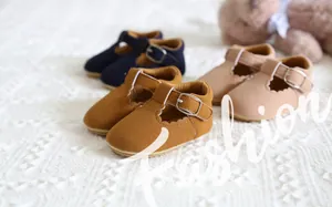 Detailed view of three pairs of soft baby princess shoes on a white knitted blanket