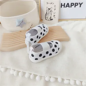 Detalle de zapatos de lona a lunares para bebés con banda elástica y suela blanda