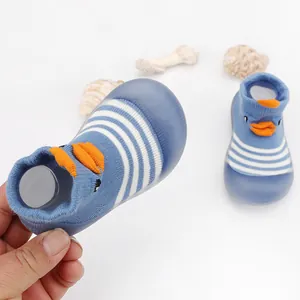 Close-up of baby indoor walker shoes featuring soft blue rubber soles and duck design.