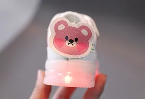 Close-up of glowing red LED light-up heel on baby walking shoe with cartoon bear