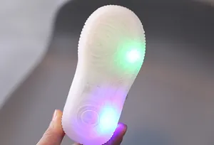 Close-up of transparent soft sole with colorful LED lights for toddler sneakers