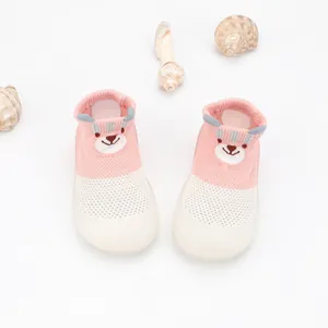 Close-up of pink and white breathable mesh baby walking shoes with cute cartoon bear pattern