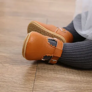 Close-up of brown baby princess walking shoes with non-slip rubber soles and buckle.