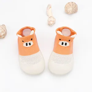 Close-up detail of breathable orange mesh baby shoes with cartoon pig face design
