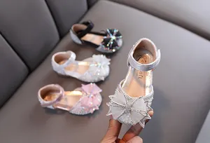 Détail de chaussures plates de princesse argentées avec nœud en strass
