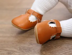 Detail view of brown baby princess shoes featuring scalloped edges and anti-slip rubber soles